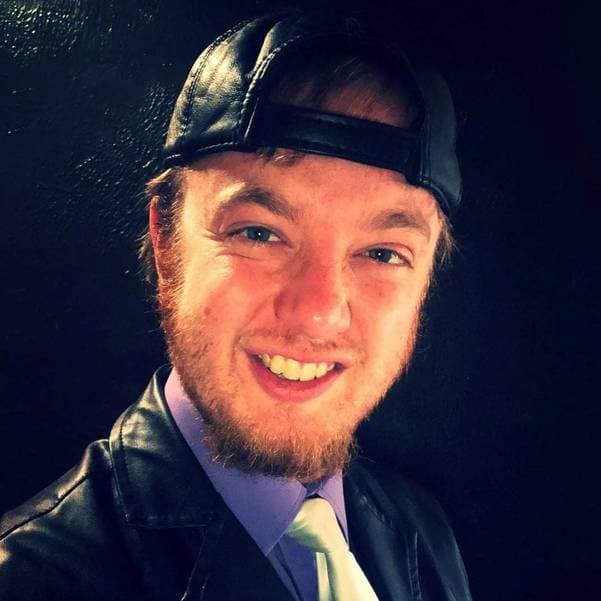 smiling selfie of luke wenke wearing a black hat and black leather jacket