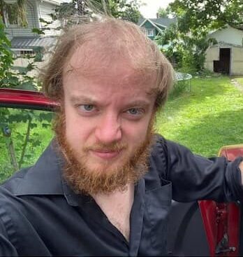 luke wenke unkempt white man standing outdoors car disheveled blonde